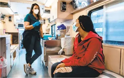  ?? ARIANA DREHSLER ?? Blossom Bess, 15, speaks to Zoe Reza, a licensed vocational nurse, at the University of California San Diego Health Mobile Vaccine Clinic before receiving her first shot of vaccine for COVID-19 at Crawford High School on Wednesday.