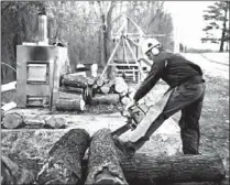  ??  ?? Darwin Woods cuts wood Friday for a wood-burning stove, which he uses to heat his workshop at his home near Clark, Mo. Woods says he considers the proposed EPA rule for new wood-stoves the latest example of an agency run amok. Proposed regulation­s from...