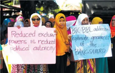  ??  ?? PREFERRED BBL VERSION – Muslim women carry signs that convey the main message of a rally they attended yesterday in Pikit, North Cotabato which sought the passage of the Bangsamoro Transition Commission (BTC) version of the Bangsamoro Basic Law (BBL)....