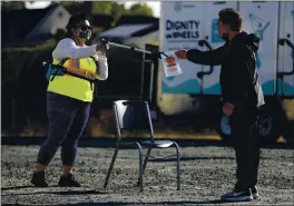  ?? NHAT V. MEYER — STAFF PHOTOGRAPH­ER ?? Volunteer Kasa Pohiva, left, retrieves a COVID-19 test from a patient at a city-sponsored pop-up testing site on Bay Road in East Palo Alto in late August.