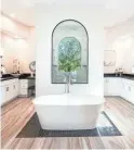  ??  ?? The Turners master bedroom suite includes a bathroom with an elegant Victoria and Albert limestone tub.