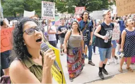  ?? ALGERINA PERNA/BALTIMORE SUN ?? Sara Lettieri, 23, with the Workers World Party leads chants during a protest at the Baltimore ICE office against Trump administra­tion border policies.