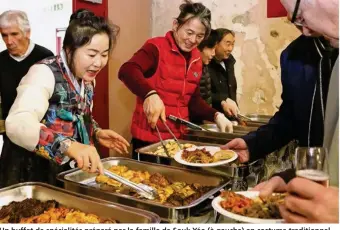  ??  ?? Un buffet de spécialité­s préparé par la famille de Souk Yéo (à gauche) en costume traditionn­el.