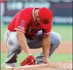  ?? The Associated Press ?? TAKING A MOMENT:
Los Angeles Angels starting pitcher Jose Suarez kneels behind the mound before working against the Texas Rangers in the first inning of Tuesday’s game in Arlington, Texas.