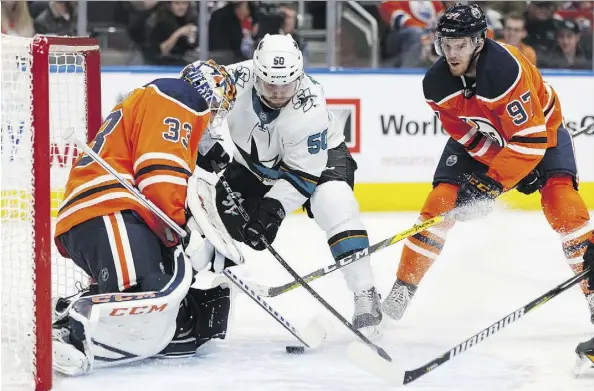  ?? IAN KUCERAK ?? Edmonton Oilers goaltender Cam Talbot denies San Jose Sharks forward Chris Tierney with help from Connor McDavid Monday during their game at Rogers Place. The Oilers were 5-3 winners, securing back-to-back wins for the host squad.