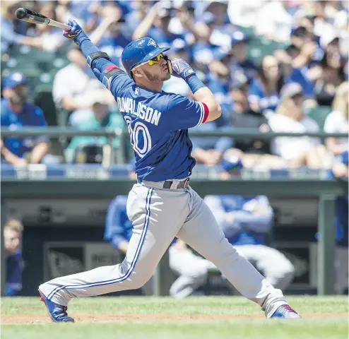  ?? STEPHEN BRASHEAR / GETTY IMAGES ?? Toronto’s Josh Donaldson follows through on a first-inning, opposite-field two-run homer off Seattle starter James Paxton in a 4- 0 win Sunday in Seattle. The Jays pulled within one game of the .500 mark with the win.