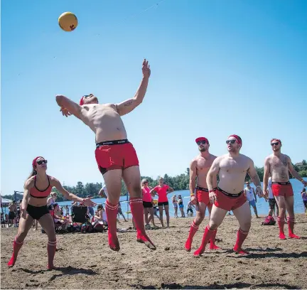  ?? PHOTOS: ASHLEY FRASER ?? Nick Rouleau of the Hit Faced team goes up to smash the ball as the sun finally came out for the 35th HOPE Volleyball SummerFest at Mooney’s Bay Park on Saturday. An estimated $150,000 was raised for six charities in the city.