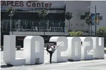  ?? JAE C. HONG ?? Yoga instructor Michael Phillip poses with a Los Angeles 2024 Summer Olympic Games statue. Los Angeles, along with other cities, is being considered.