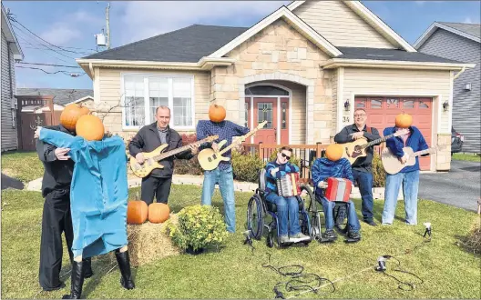  ?? ROSIE MULLALEY/THE TELEGRAM ?? Members of The Brandon Bowen Band pose with their pumpkin head figures at 34 Tryell Dr. in Paradise. The display, created by homeowners Russ and Pamela Molloy, is attracting plenty of attention in the neighbourh­ood. From left, bass player David Spurvey, Brandon Bowen on accordion and Russ Molloy, who plays guitar.