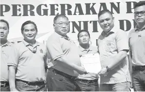  ??  ?? TIONG (tiga kiri) menerima borang keahlian kemasukan ahli PDP disampaika­n Kelvin Ting.