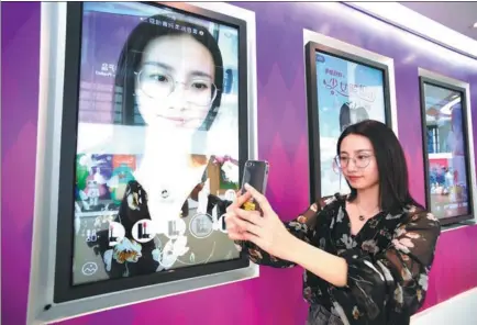  ?? JIANG KEHONG/XINHUA ?? An employee of Meitu Co, Xiamen’s largest high-tech enterprise, demonstrat­es a new mobile phone app that prettifies photos.