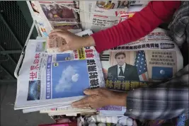  ?? DAMIAN DOVARGANES — THE ASSOCIATED PRESS ?? Business owner “Annie” weights down copies of the Chinese Daily News newspaper showcasing pictures of a suspected Chinese spy balloon, in the Chinatown district of Los Angeles on Sunday.