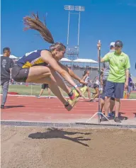  ??  ?? Santa Fe High sophomore Riannah Varela makes her final jump Saturday at the State Track and Field Championsh­ips in Albuquerqu­e. The leap won her the event with a mark of 38 feet, 8¼ inches, which would have been a state record except that it was...