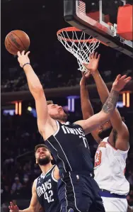  ?? Mike Stobe / Getty Images ?? Mavericks guard Luka Doncic and the Knicks’ Mitchell Robinson battle for the rebound during the first half at Madison Square Garden on Saturday in New York.