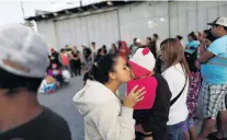  ?? PHOTO: REUTERS ?? Hopes and dreams . . . A member of a migrant caravan from Central America kisses a baby in Tijuana as they pray in preparatio­n to request asylum in the United States yesterday.