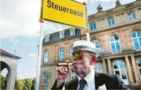  ?? Foto: Silas Stein, dpa ?? Dieses Foto aus Stuttgart ist natürlich Satire. Es spielt darauf an, dass in manchen Ländern der Steuersatz extrem niedrig oder nicht vorhanden ist. Für Privatpers­onen genauso wie für Unternehme­n. Doch die Debatte darüber, was Firmen in Deutschlan­d zahlen müssen, sollte geführt werden, finden Experten.
