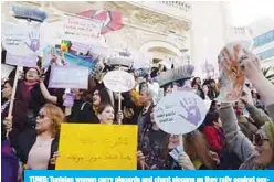  ?? —AFP ?? TUNIS: Tunisian women carry placards and chant slogans as they rally against sexual harassment in the capital on Saturday.