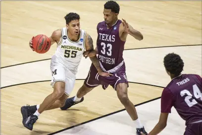  ?? PHOTOS BY ROBERT FRANKLIN — THE ASSOCIATED PRESS ?? Michigan’s Eli Brooks (55) drives against Texas Southern’s Quinton Brigham (33) during the second half of a first-round game in the NCAA Tournament on Saturday at Mackey Arena in West Lafayette, Ind.