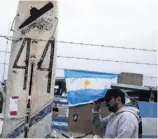  ?? PHOTO: REUTERS ?? A man walks past signs and messages in support of the 44 crew members of the missing submarine San Juan, placed on a fence at an Argentine naval base in Mar del Plata, Argentina, yesterday.