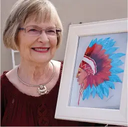  ?? Staff photo by Neil Abeles ?? ■ Virginia Hooten is showing for the first time some of the artistic works she has begun creating in her retirement years. She especially likes this Native American head work since she was first asked by a family member to paint the bonnet. “After doing the bonnet, I decided to add a face,” she said. “That was my own gift to the creation.” Virginia most enjoys painting in acrylic paints on wood.