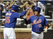  ?? KATHY KMONICEK — THE ASSOCIATED PRESS ?? New York Mets’ Ruben Tejada (11) is greeted by Kelly Johnson at the plate after Tejada’s inside-the-park home run off Philadelph­ia Phillies starter Aaron Nola in the second inning Wednesday in New York.