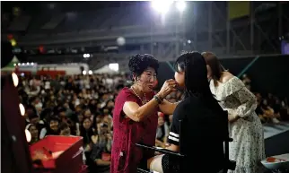  ??  ?? PARK MAK-RYE, a 70-year-old YouTuber, puts on makeup on a volunteer at a makeup show during DIA Festival in Seoul, South Korea, July 16.