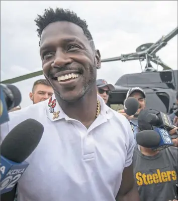  ?? Steph Chambers/Post-Gazette photos ?? Antonio Brown, with his mode of transporta­tion behind him, greets the crush of media as he arrives Wednesday for the start of training camp at Saint Vincent College in Latrobe.