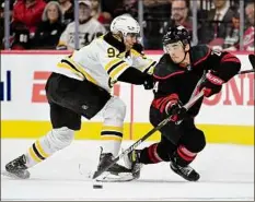  ?? Grant Halverson / Getty Images ?? Carolina’s Seth Jarvis, right, looks to evade Boston’s Tomas Nosek in Game 1. Jarvis had the first goal of the game.