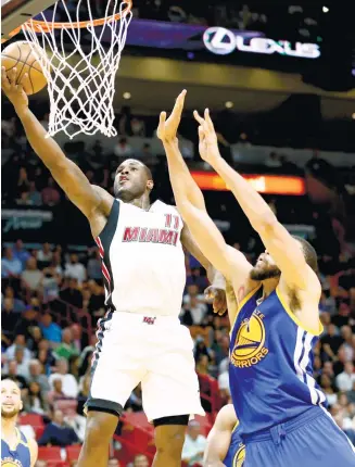  ??  ?? Miami Heat guard Dion Waiters (left) goes up for the basket against Golden State Warriors center JaVale McGee.