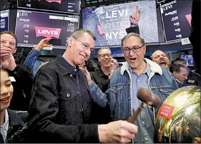  ?? AP/RICHARD DREW ?? Levi Strauss Chief Executive Officer Chip Bergh (left) is joined by Chief Financial Officer Harmit Singh as he rings a ceremonial bell Thursday when his company’s initial public offering begins trading on the New York Stock Exchange.