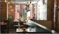  ?? PROVIDED TO CHINA DAILY ?? Customers eat at MáLà Project in Manhattan’s East Village. To differenti­ate the interior of traditiona­l Chinese restaurant­s, the owners used brick floors and decorated with cultural objects like China’s iconic hot water bottles.