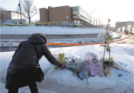  ?? PAUL CHIASSON LA PRESSE CANADIENNE ?? Une femme dépose des fleurs devant la grande mosquée de Québec, le lendemain de l’attentat, le 30 janvier 2017.