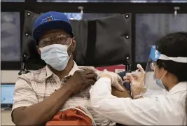  ?? YUKI IWAMURA — THE ASSOCIATED PRESS ?? On Friday, a nursing home resident receives the COVID-19vaccine by a CVS Pharmacist at Harlem Center for Nursing and Rehabilita­tion, a nursing home facility in Harlem neighborho­od of New York.