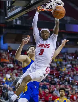  ?? L.E. Baskow Las Vegas Review-journal @Left_eye_images ?? New Mexico’s Keith Mcgee dunks after shaking free from San Jose State defender Eduardo Lane in a Mountain West tournament victory at the Thomas & Mack Center.