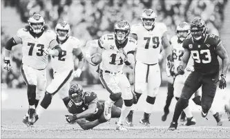  ?? TIM IRELAND THE ASSOCIATED PRESS ?? Philadelph­ia Eagles quarterbac­k Carson Wentz (11) scrambles during the first half of an NFL football game against Jacksonvil­le Jaguars at Wembley stadium in London on Sunday.