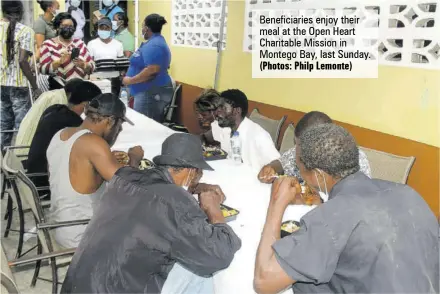  ?? (Photos: Philp Lemonte) ?? Beneficiar­ies enjoy their meal at the Open Heart Charitable Mission in Montego Bay, last Sunday.