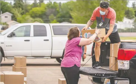  ?? MATT SMITH ?? Saskatoon Public Schools Foundation staff and volunteers load up food and educationa­l tools on Tuesday to distribute to families as part of their Cheer Crates Campaign, About 700 of the boxes were delivered to families from more than 40 schools across the city.