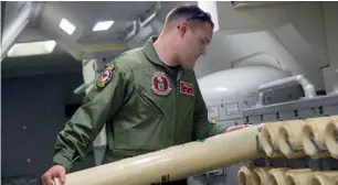  ?? AP ?? An airman unloads a sonobuoy from a rack onboard a P-8A Poseidon aircraft, during a search mission looking for the missing Malaysia plane over the southern Indian Ocean. —