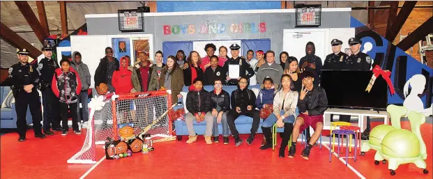  ?? Ernest A. Brown photos ?? Woonsocket Police Officers Ron Marcos, Chris Bouvier, Mike Velino, Joe Brazil, Matt Labine, and Daniel Wild, join John Bergeron, president of Johnny’s Home Furnishing’s in presenting $2,800 in gifts to members of the Woonsocket Boys and Girls Club Teen...