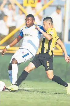  ??  ?? TALENTO. El lateral Elmer Güity, uno de los mejores del Olimpia, intenta irse de la marca del aurinegro Jairo Puerto.