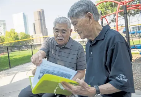  ?? Daniel Brenner, Special to The Denver Post ?? Art Arita, left, and Mas Yoshimura look through a photo album over the summer at Lawson Park. The two played on the Denver Nisei team together in the late 1940s and early 1950s.