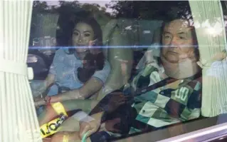 ?? AP PHOTO ?? PAROLE
Former Thai prime minister Thaksin Shinawatra (right) sits in a vehicle with his daughter Paetongtar­n in front of his residence after being released on parole, Sunday, Feb. 18, 2024, in Bangkok, Thailand.