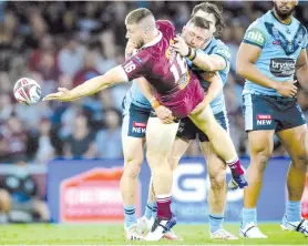  ?? - AFP photo ?? Queensland player Jai Arrow (L) offloads as he is tackled by New South Wales player Damien Cook (R) during the State of Origin rugby league match between Queensland and New South Wales in Brisbane.