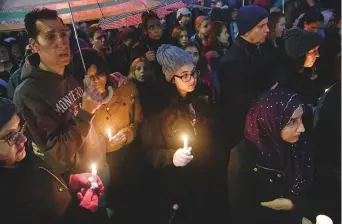  ?? Washington Post ?? Mourners participat­e in a vigil on Saturday evening in the Squirrel Hill neighbourh­ood of Pittsburgh, where 11 people were killed in a mass shooting at the Tree of Life Synagogue.