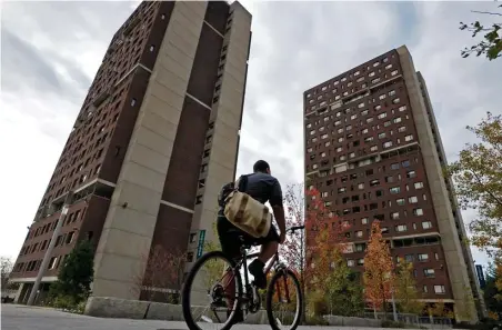  ?? CHRISTOPHE­R EVANS / HERALD STAFF FILE ?? FOLLOW THE MONEY: A cyclist rides past two residence halls in 2012 at the UMass-Amherst campus. UMass administra­tors added to their already-large salaries with various bonuses, buyouts and other payments in 2018.