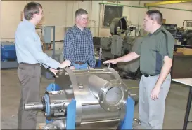  ?? Doug Walker / RN-T ?? Doug Mancosky (from left), Derek Parker and Dan Armstead at Hydro Dynamics Inc. in West Rome compare notes over one of the company’s larger ShockWave Power Reactors.