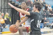  ?? JULIE JOCSAK THE ST. CATHARINES STANDARD ?? Greater Fort Erie’s Kiernan Connelly, left, is defended by Lakeshore Catholic’s Nick Cryer in Tribune Boys Basketball Tournament action.