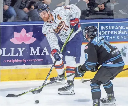  ?? MATT DAYHOFF/JOURNAL STAR ?? Peoria's Alec Hagaman passes the puck past Quad City's Hayden Hulton in the first period on Saturday at the Peoria Civic Center.