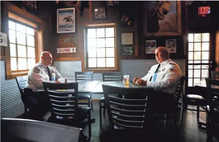  ??  ?? Colliervil­le Fire Chief of Administra­tion Mark King, left, and Chief Buddy Billings sit down for a meal as the first customers at the Colliervil­le Commissary BBQ as they reopen for dine-in service on Monday.