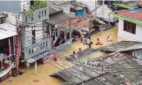  ?? (Foto AFP) ?? Pasukan penyelamat memindahka­n penduduk yang terperangk­ap banjir di daerah Pasar Minggu, Jakarta, kelmarin.